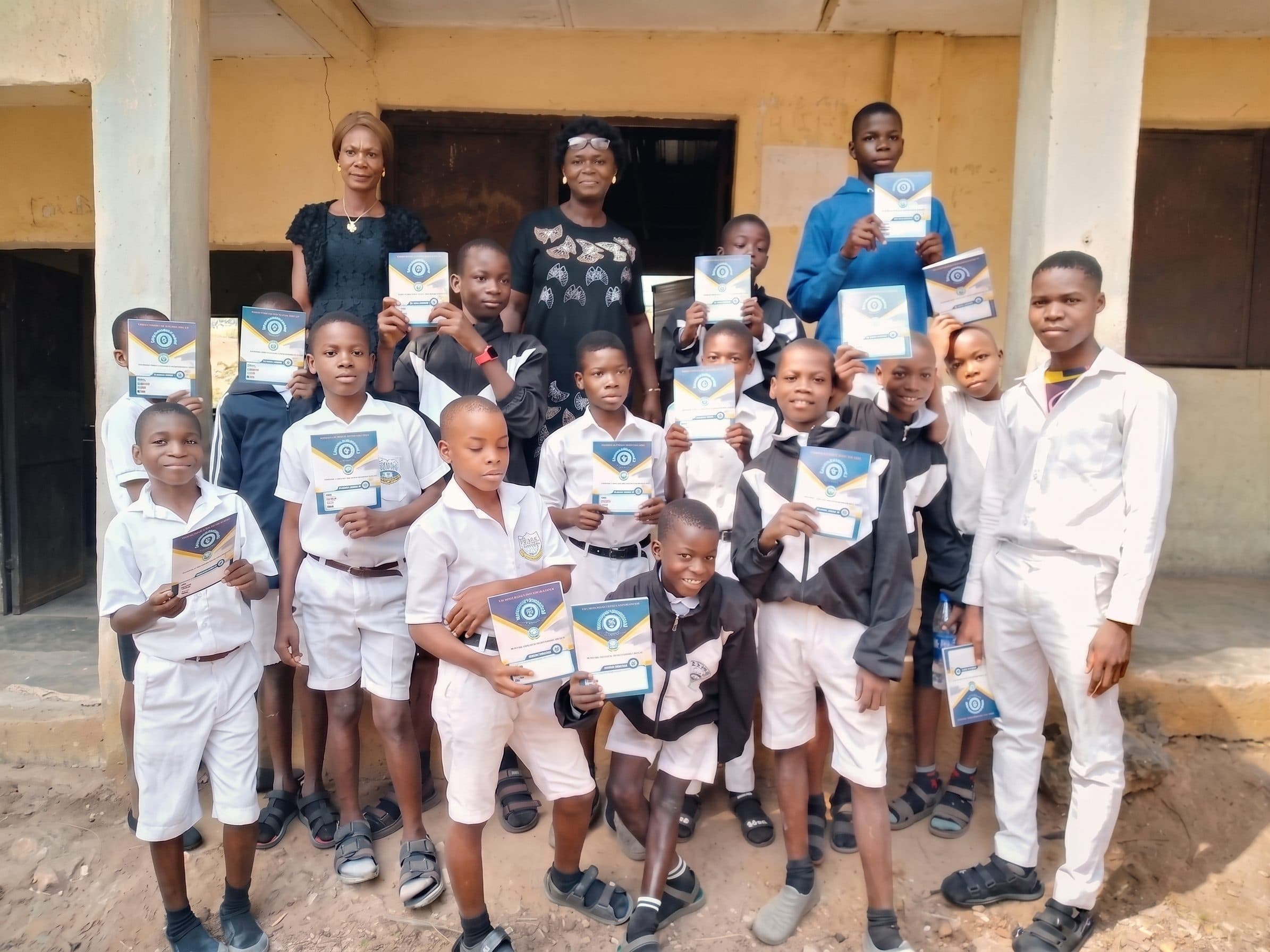 Students receiving Obu Ihuoma-branded exercise books, educational support initiative